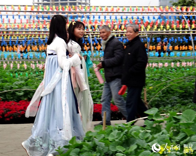 热闹的民俗文化节引来不少市民，图为三位穿汉服的女孩引得游客侧目